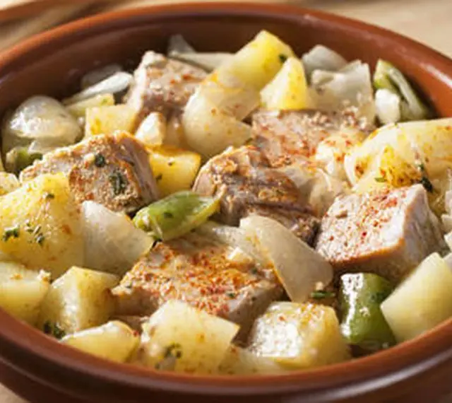 Un delicioso marmitako de atún con patatas, pimientos y cebolla en una cazuela de barro.
