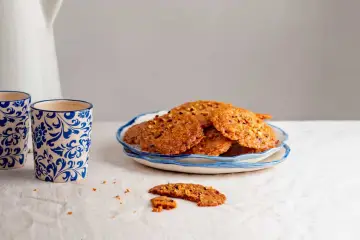 Deliciosas galletas de jengibre con trocitos de nuez, servidas en un plato azul y blanco.