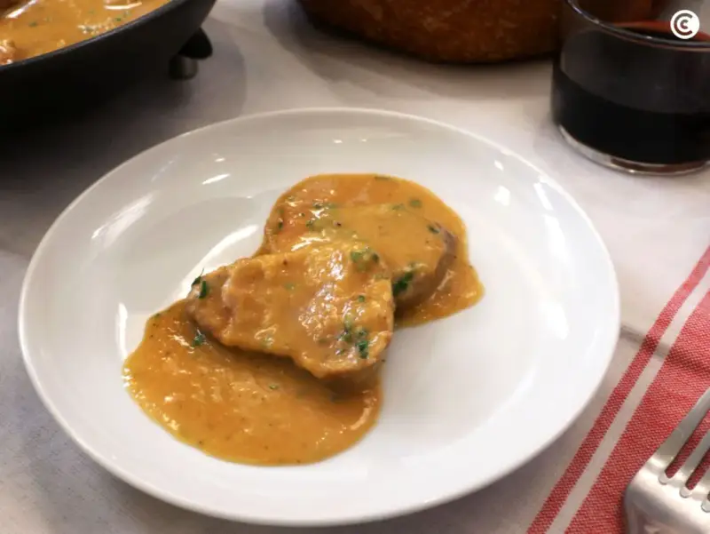 Dos medallones de solomillo al ajillo en una salsa cremosa, servidos en un plato blanco.